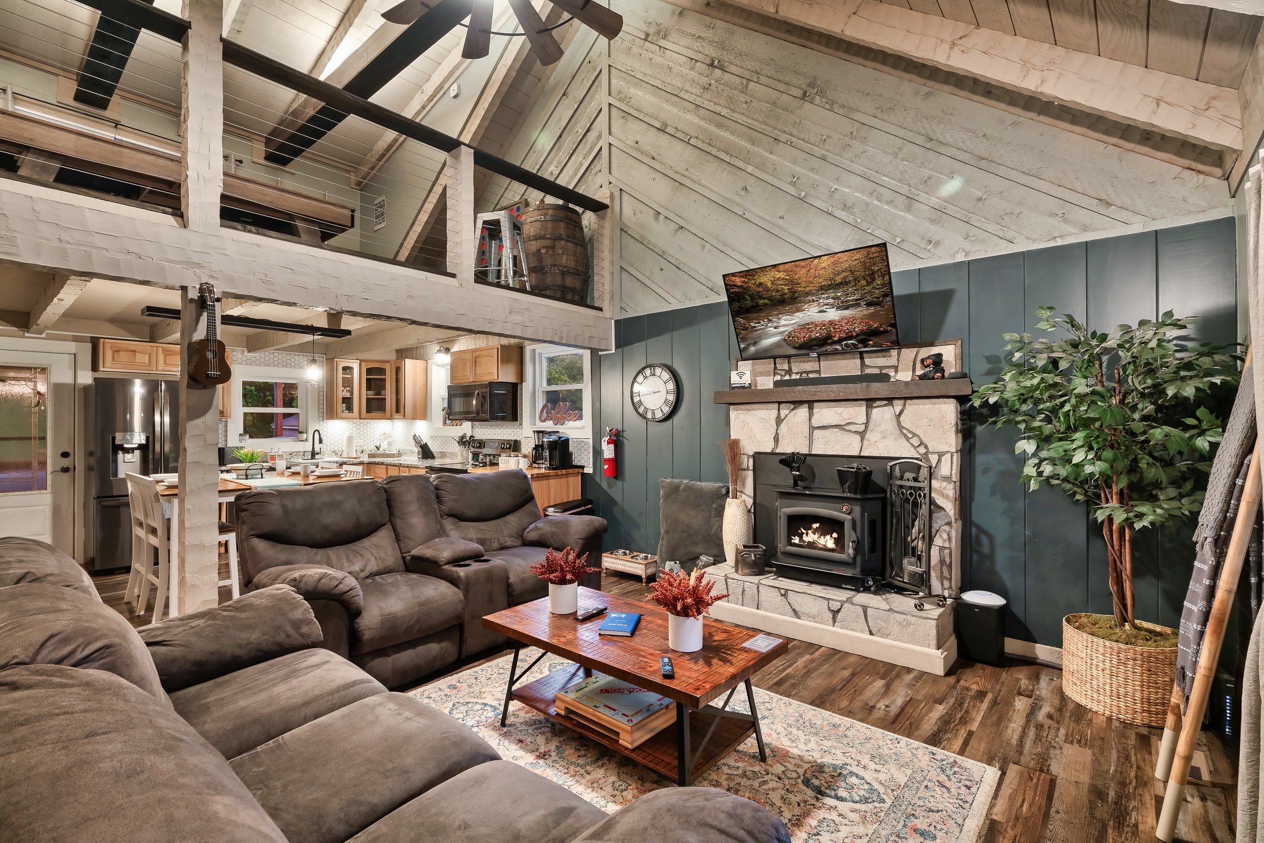Hillside Haven living room with vaulted ceiling, stone fireplace, and open kitchen in Tennessee