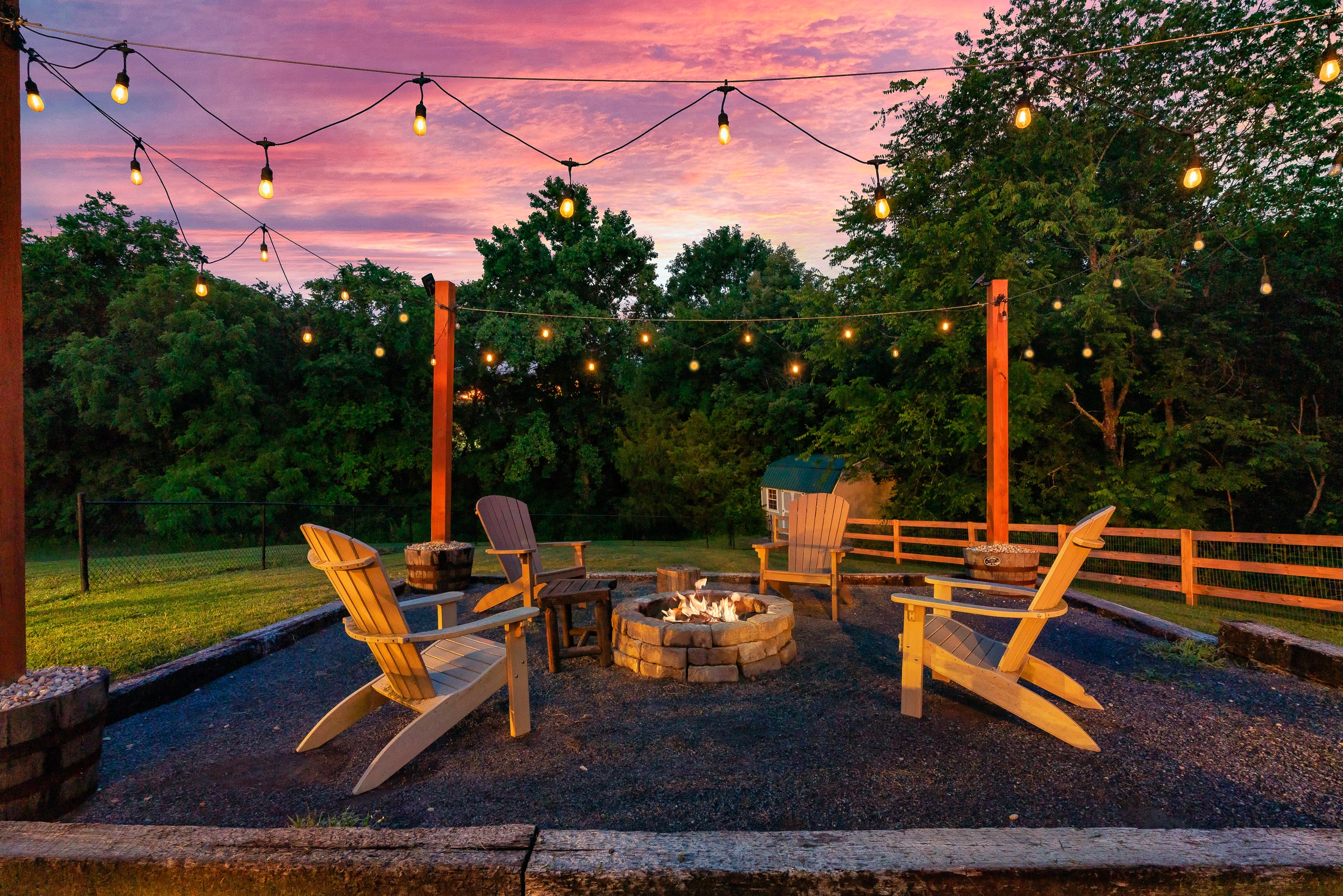 Hillside Haven fire pit with Adirondack chairs and string lights at sunset in Tennessee
