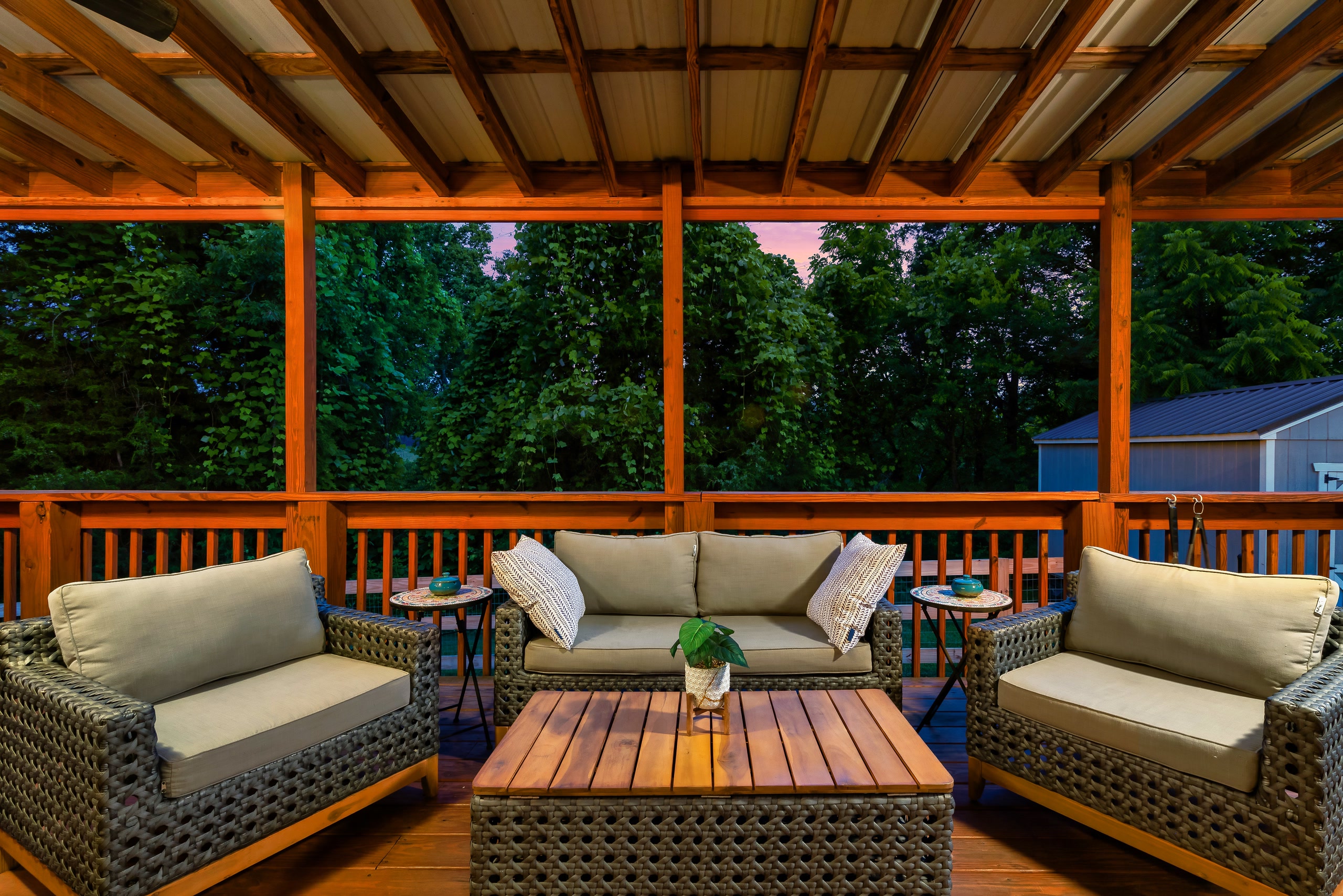 Hillside Haven covered deck with wicker furniture overlooking Tennessee forest
