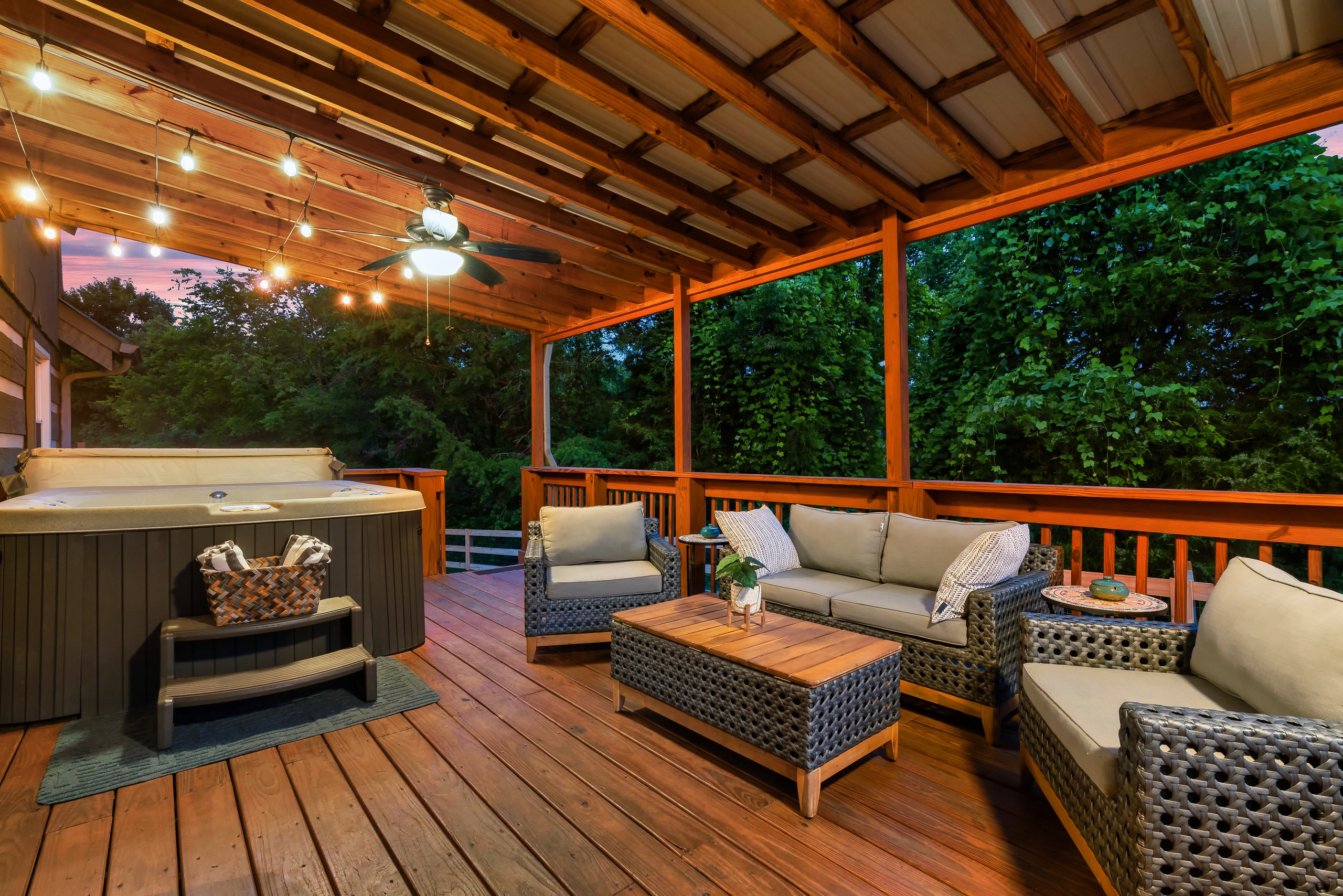 Hillside Haven covered deck with hot tub and seating at dusk in Tennessee
