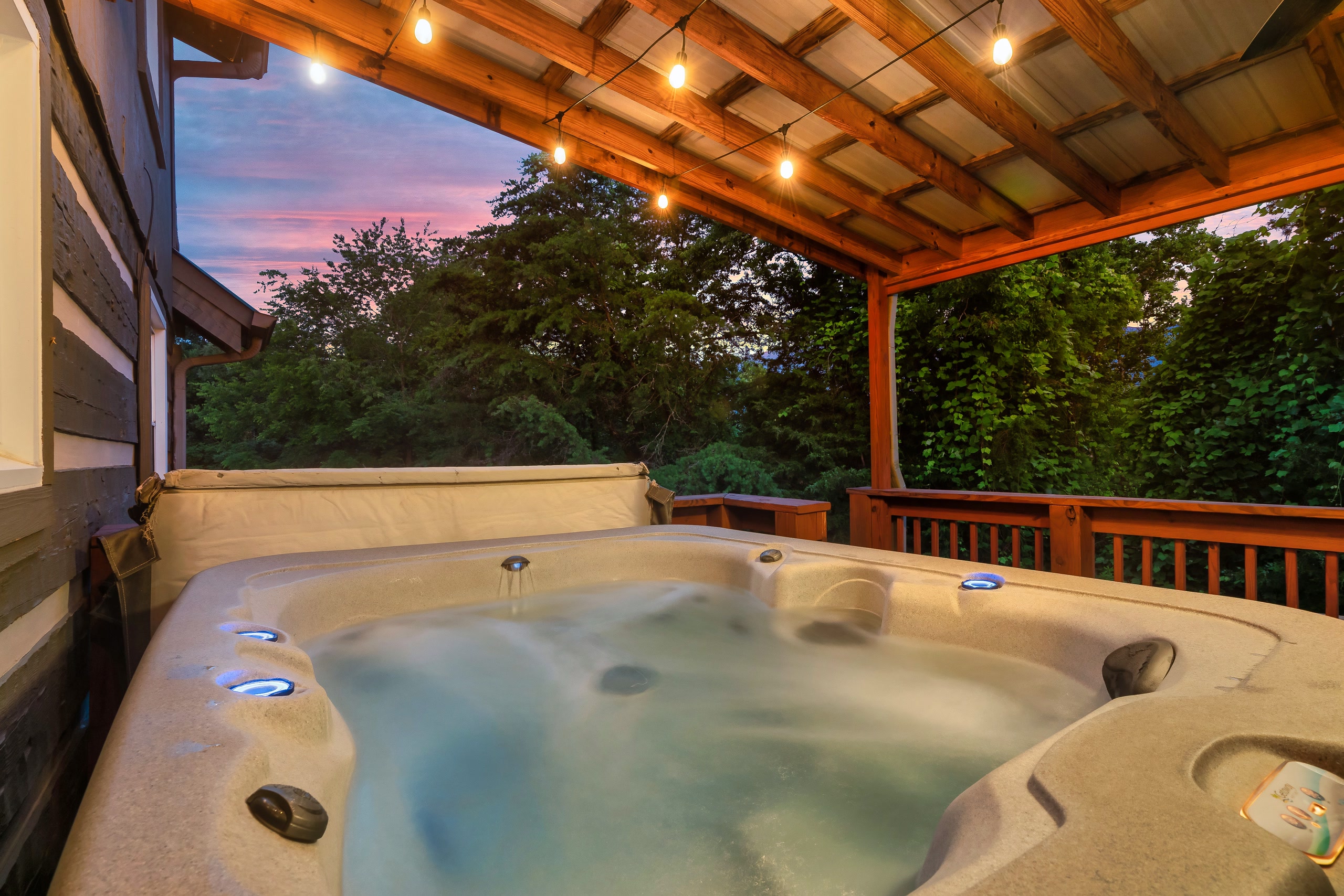 Hillside Haven hot tub interior view with string lights at dusk in Tennessee