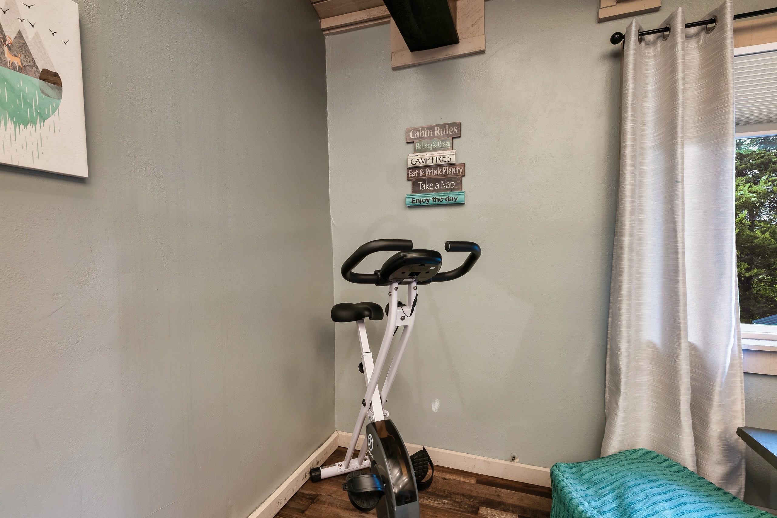 Hillside Haven game room with exercise bike and cabin rules signs in Tennessee
