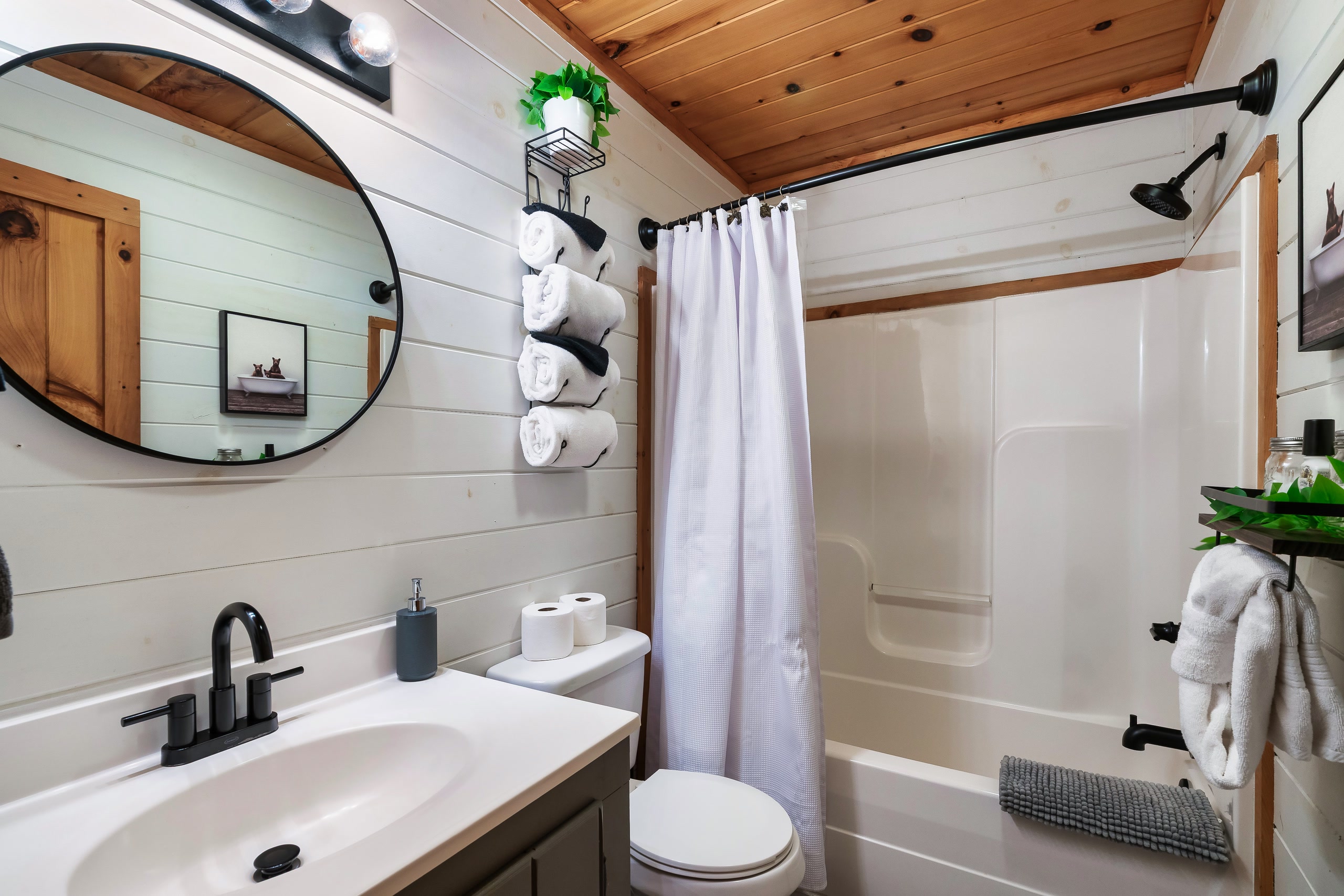 Smoky Creek Hideaway bedroom with log bed, barn door, and vaulted wood ceiling