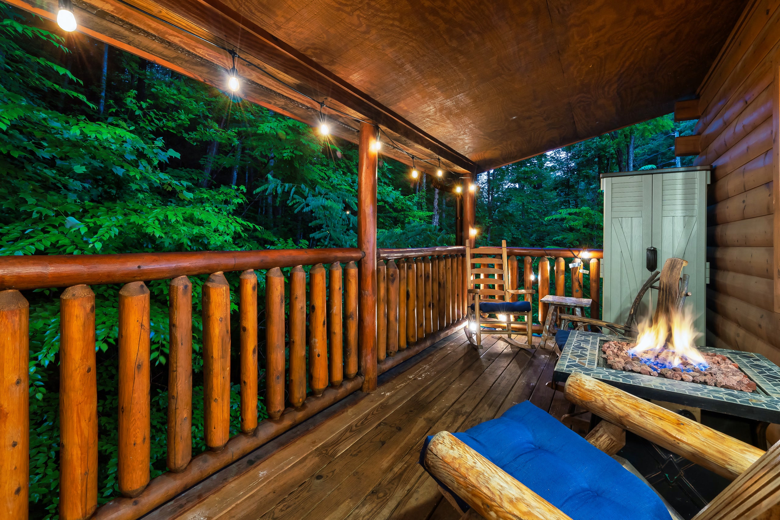Smoky Creek Hideaway covered deck with fire pit and forest views at twilight