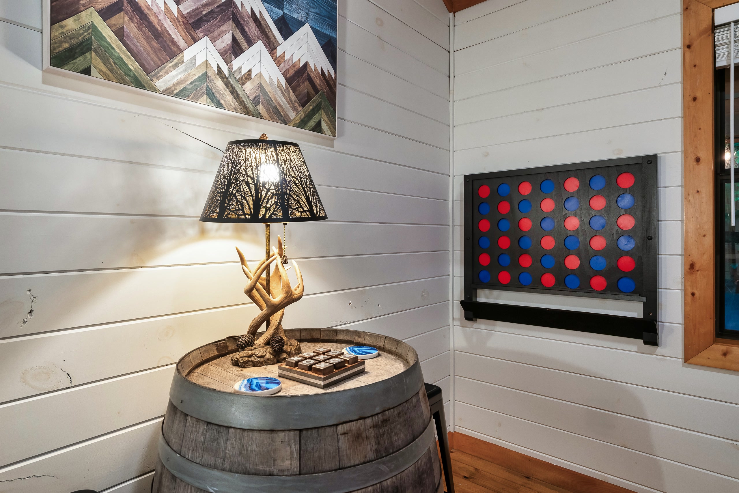 Whiskey barrel table with antler lamp and Connect Four at Tennessee cabin