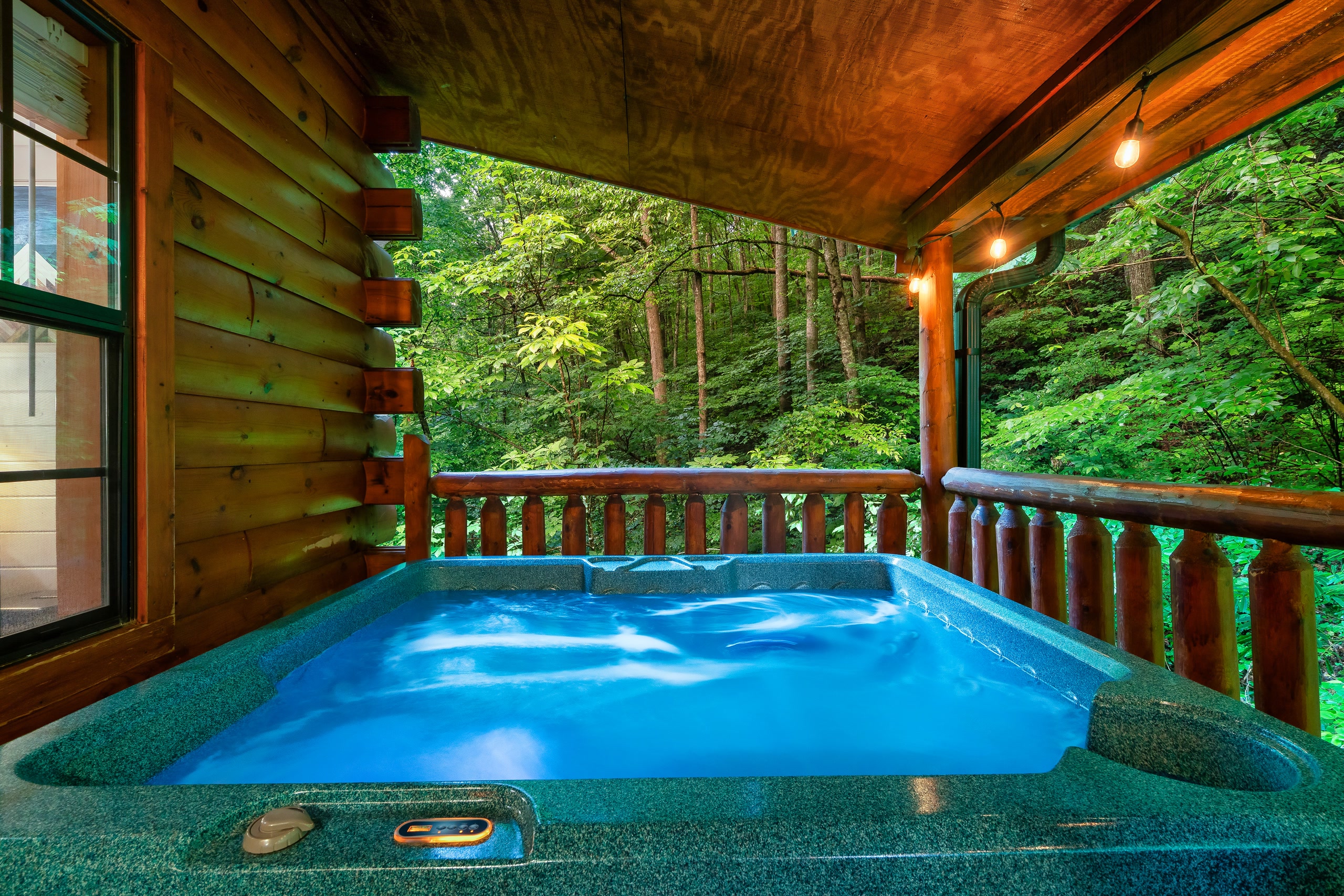 Hot tub on covered deck with forest views at Tennessee mountain cabin