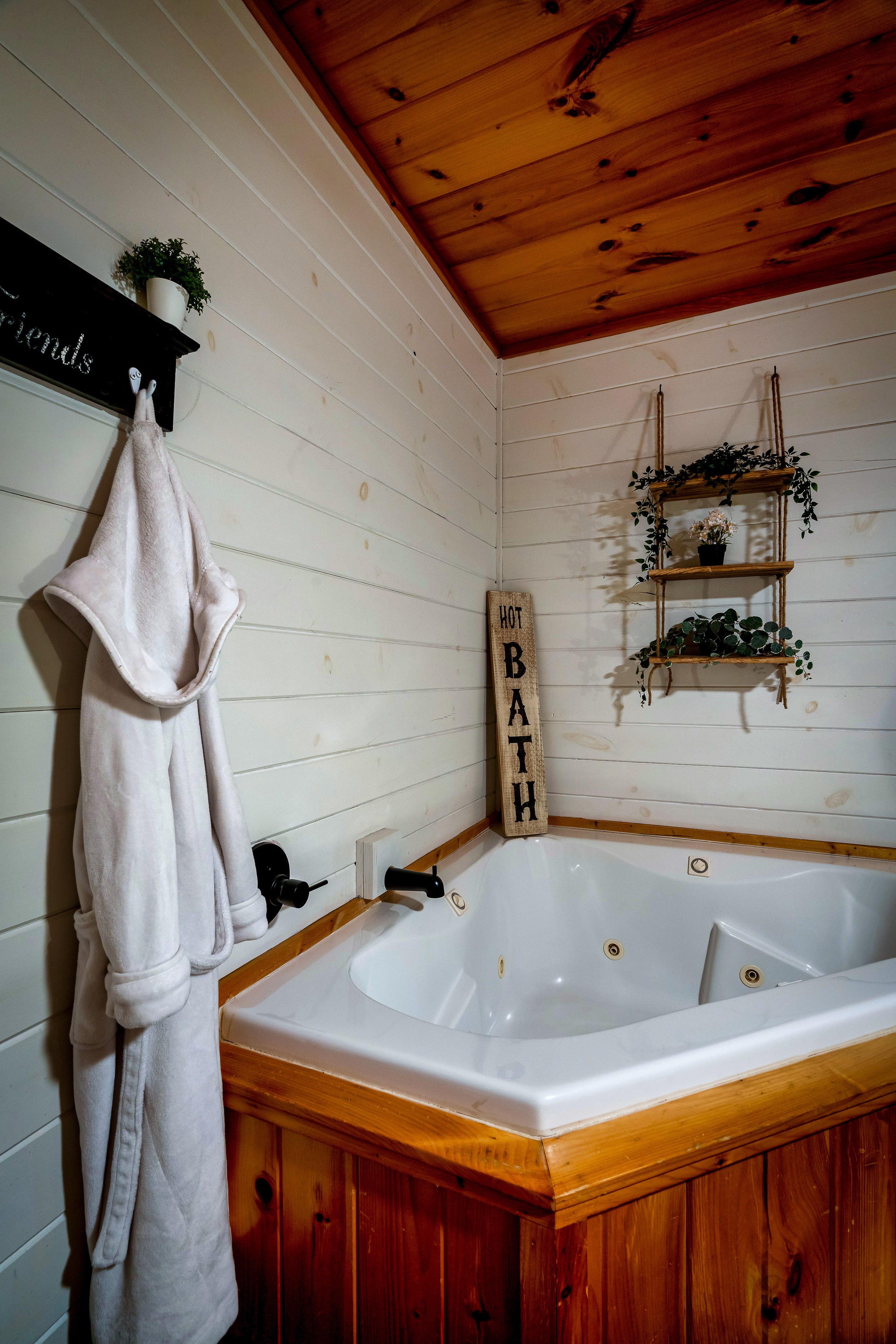 Corner jetted tub with robes and shelves at Smoky Creek Hideaway