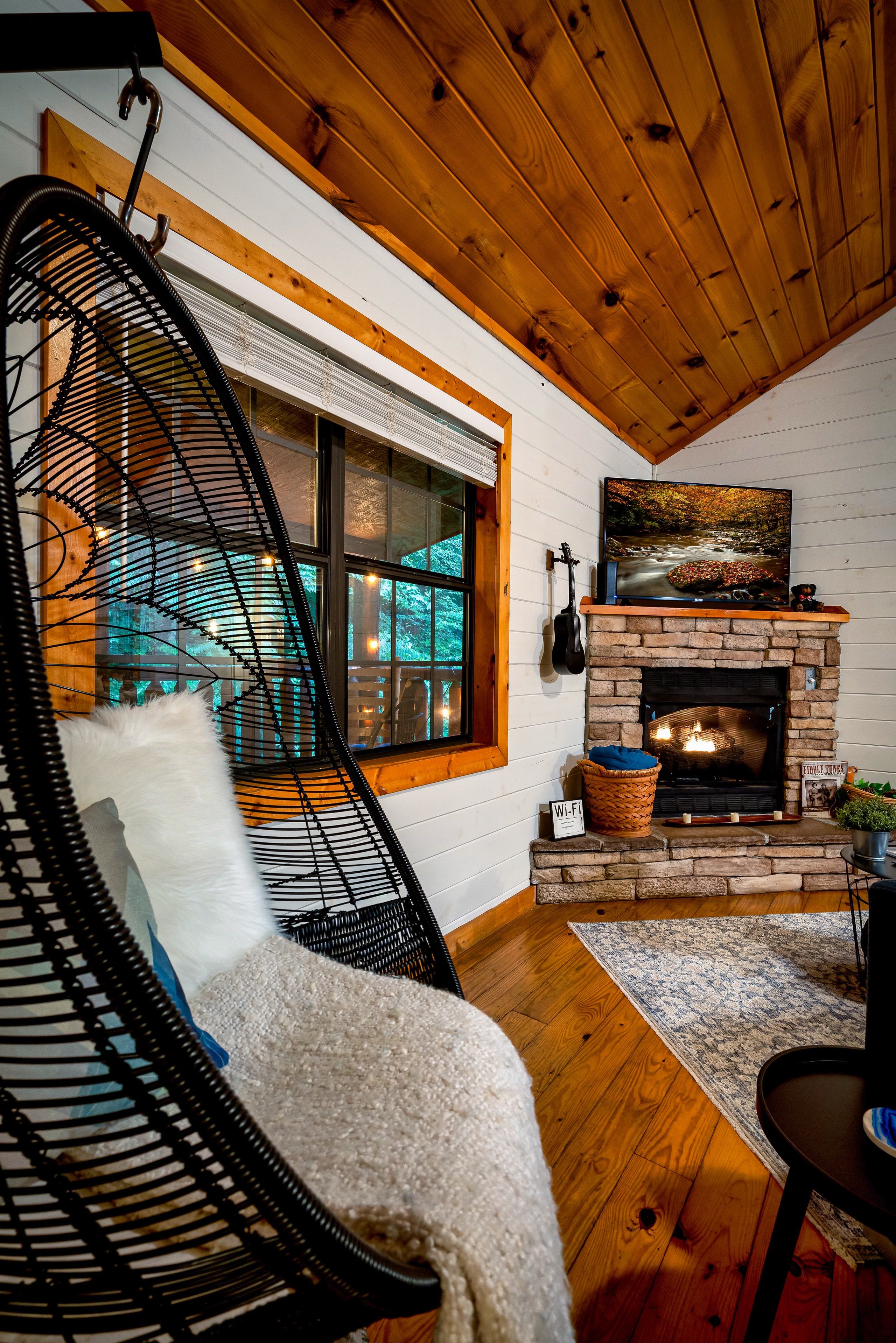 Hanging bubble chair and stone fireplace at Tennessee mountain cabin