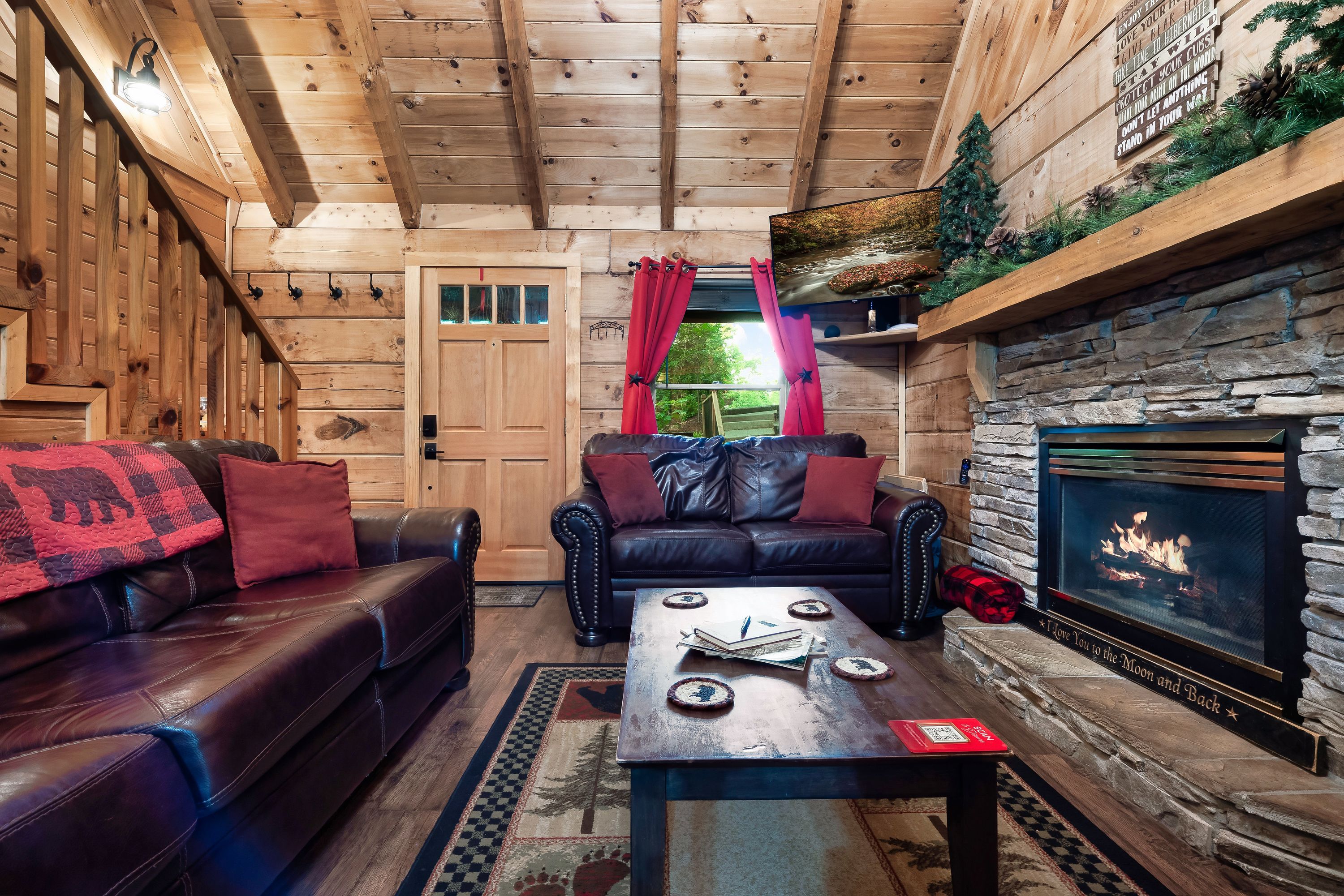 Rustic Rooster living room with leather sofas and lit stone fireplace